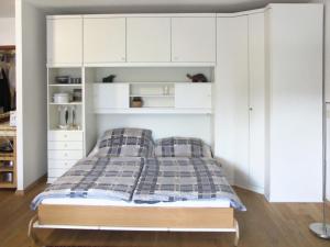 格洛韦Apartment Glowe - GLW650 by Interhome的一间卧室配有一张床和白色橱柜