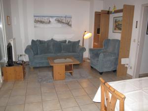 岑平Apartment Achterwasser - ZEM104的客厅配有2张蓝色的沙发和1张桌子