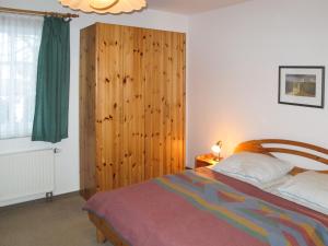 岑平Apartment Achterwasser - ZEM104的一间卧室配有一张床和一个木制橱柜