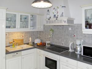 岑平Apartment Hortensie - ZEM108 by Interhome的厨房配有白色橱柜和水槽