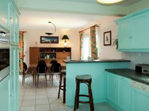 Trégastel-PlageHoliday Home Palacret - TGP306 by Interhome的厨房配有蓝色橱柜和酒吧凳子