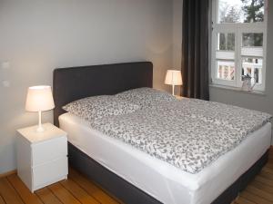 卢布明Apartment Villa am Meer by Interhome的一张带黑白棉被的床和两盏灯