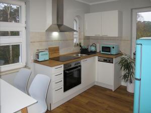 卢布明Apartment Villa am Meer by Interhome的厨房配有白色橱柜和炉灶烤箱。