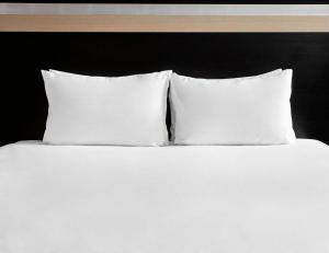 布里斯托假日布里斯托尔市中心酒店的一张白色的床,上面有三个枕头