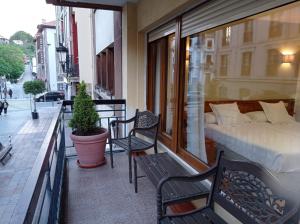 坎加斯-德奥尼斯托雷翁旅馆的阳台配有床和2把椅子