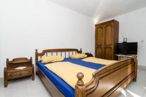 德雷斯Apartments Lemeš的一间卧室配有两张床和电视。
