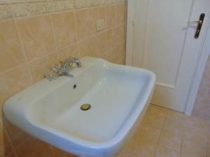 普莱伊亚诺Casa la lampara的浴室设有白色水槽,浴室设有门