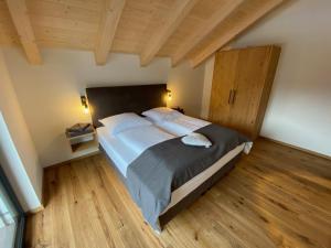 平茨高谷地霍勒尔斯巴赫Our's Living的一间卧室设有一张大床,铺有木地板