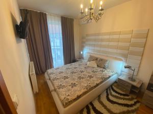 豪伊杜索博斯洛Thermal Lux apartman的一间卧室配有一张床和一个吊灯