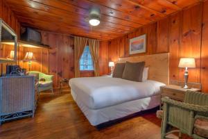 Linville FallsLinville Falls Lodge & Cottages的卧室配有一张床铺,位于带木墙的房间内