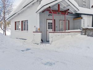 HyrynsalmiHoliday Home Hallantytär b3 paritalo by Interhome的前面有一堆积雪的房子