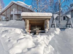 HyrynsalmiHoliday Home Hallantytär b3 paritalo by Interhome的一座房子,被雪覆盖,设有壁炉
