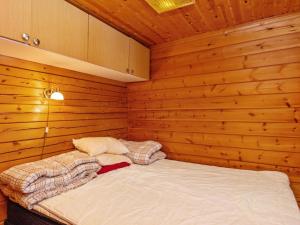 KotilaHoliday Home Lohiukko by Interhome的小房间,木墙里设有一张床