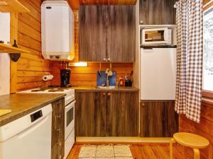 KotilaHoliday Home Lohiukko by Interhome的厨房配有木制橱柜和白色冰箱。