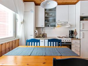 KotilaHoliday Home Lomarivi c4 by Interhome的厨房配有木桌和蓝色椅子