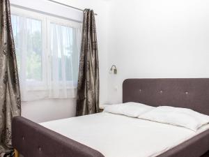 鲍洛通拜雷尼Holiday Home Francois by Interhome的一张带白色床单的床和窗帘的窗户