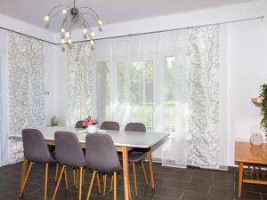 鲍洛通拜雷尼Holiday Home Francois by Interhome的一间设有白色窗帘和桌椅的用餐室