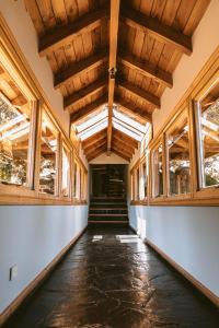 圣马丁德洛斯Arrayan Lake View Mountain Lodge & Casa De Te Arrayan的空的走廊设有木制天花板和窗户