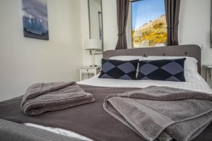 蒂恩格Rona@Knock View Apartments, Sleat, Isle of Skye的一间卧室配有一张床,上面有两条毛巾