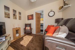 蒂恩格Rona@Knock View Apartments, Sleat, Isle of Skye的客厅配有沙发和墙上的时钟