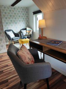 SliteGothem Viby Bed&Breakfast的客厅配有书桌和带枕头的椅子
