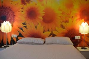索里亚EL RAMILLETE的卧室配有一张带向日葵的床铺,墙上挂有向日葵
