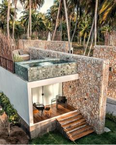 佩德拉斯港Pedras Do Patacho Hotel Boutique Experience的一座带小型游泳池和石墙的房子