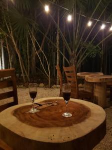 莫雷洛斯港Aldea Maya-Ha Cabañas con cenotes的木桌旁放两杯葡萄酒