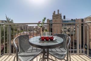 耶路撒冷耶路撒冷帕蒙尼公寓酒店的阳台上的桌子上放着三只苹果