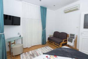 布尔加斯Портхаус的一间卧室配有一张床、一张沙发和一把椅子