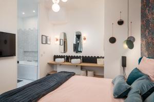 里昂Le Cocon Hygge & SPA的一间带大床和电视的卧室