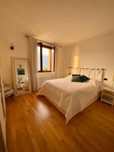 布里维奥Appartment in Blevio; stunning view of the lake的卧室设有一张白色大床和木地板