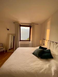 布里维奥Appartment in Blevio; stunning view of the lake的卧室配有一张大白色床和窗户
