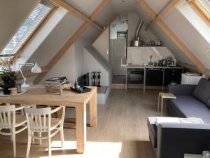 西姆斯科克BBOosterweg3 Studio的一间带木桌的客厅和一间厨房