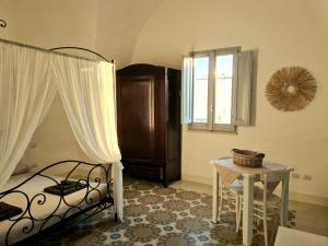马蒂诺La Casa dei Bombi Nettare & Polline的一间卧室配有一张床、一张桌子和一个窗户。