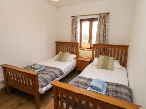 BactonHill Farm Cottage的带窗户的客房内设有两张单人床。