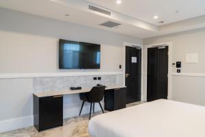 悉尼Holiday Inn & Suites - Parramatta Marsden Street, an IHG Hotel的酒店客房配有一张床和一张书桌及一台电视