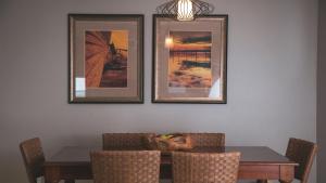 达文波特Holiday Inn Club Vacations - Orlando Breeze Resort, an IHG Hotel的一间用餐室,配有一张桌子和三张墙上的照片
