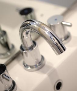 雅加达朱安达阿马里斯酒店的浴室水槽配有银色水龙头