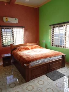 阿克拉Justa Hotel Annex的一间卧室设有一张带绿色墙壁和窗户的床。