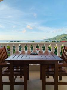 博瓦隆Oceanic View Apartments的阳台上配有一张木桌和两把椅子