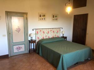 科尔萨诺Agriturismo Fattoria Di Corsano的一间卧室配有一张带绿床罩的床