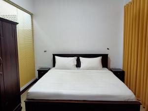 哈顿Greenfield Bedz的一间卧室配有一张带白色床单的床和一扇窗户。
