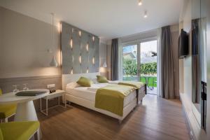 巴多利诺Hotel Villa Olivo Resort 3S的一间卧室配有一张床、一张桌子和一台电视