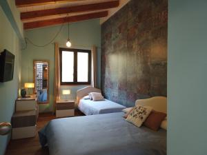 阿曼泰阿Il Mandorlo的一间卧室设有两张床和砖墙
