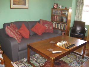 库姆马丁橡子酒店的客厅配有沙发和棋盘(桌子上)