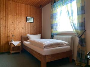 尼尔廷根Hotel Garni Siedlerstube的一间小卧室,配有一张带窗户的床