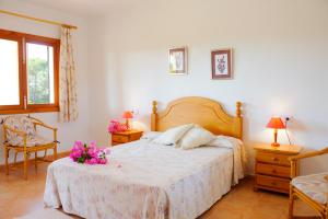 卡拉蒙德拉戈Finca Torrent Des Jai的一间卧室,床上放着鲜花