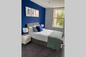 珀斯Stunning 2 Bedroom River View Apartment的蓝色的卧室设有床和窗户