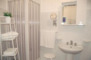 兰佩杜萨卡赛藩肯西法奇卡拉酒店的白色的浴室设有水槽和淋浴。